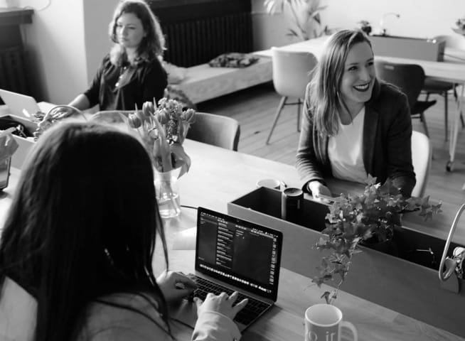 three people working and laughing on a table